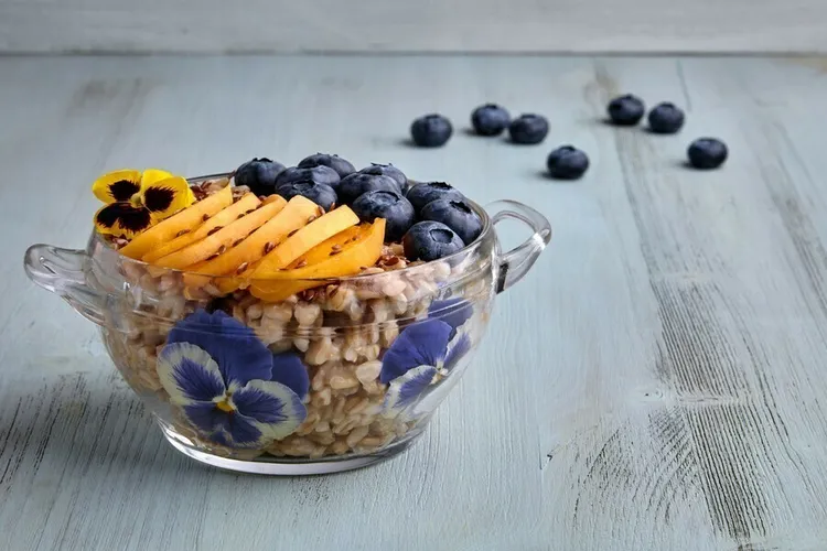 Blueberry peach oatmeal bowl with almond butter and flaxseed