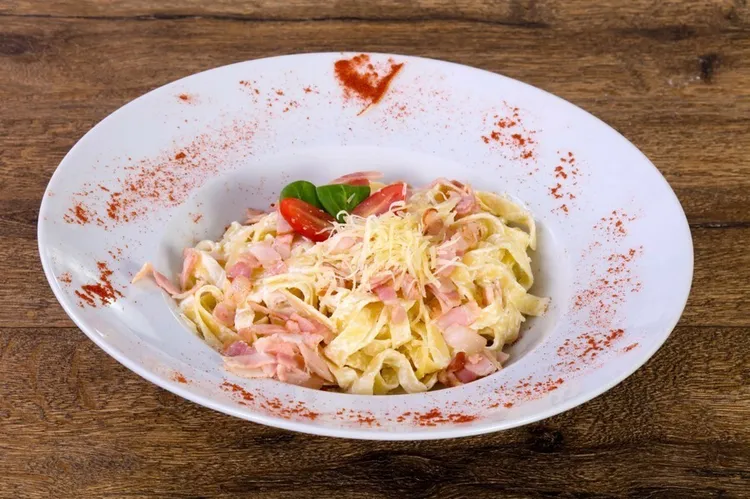 Fettuccine with prosciutto, tomatoes, bacon and creamy parmesan sauce