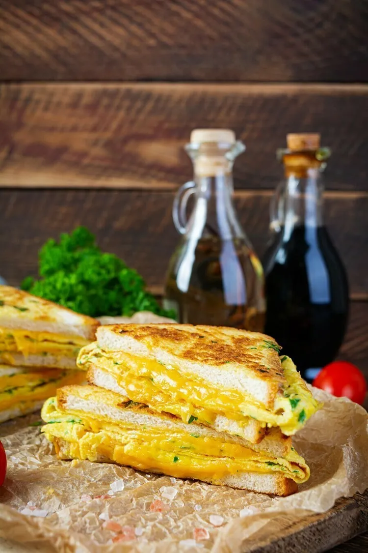 Bacon and egg grilled cheese sandwiches with basil and parmesan
