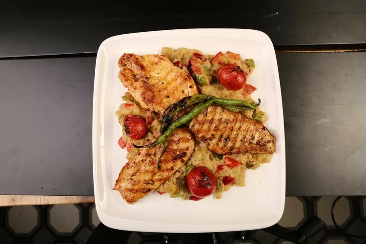 Grilled mediterranean chicken with cherry tomatoes, olives and capers