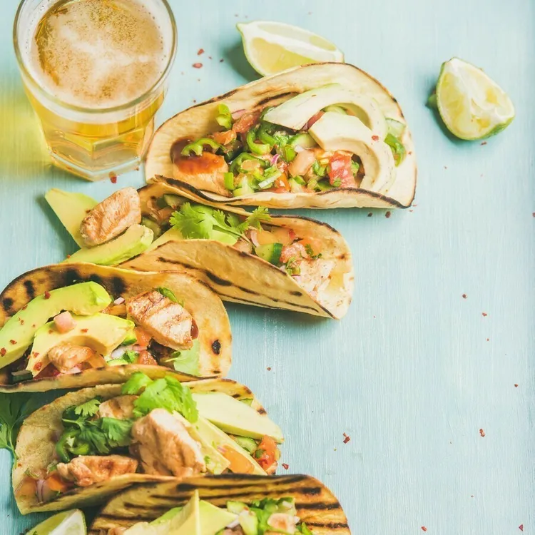 Grilled tilapia fish tacos with cabbage, avocado and lime