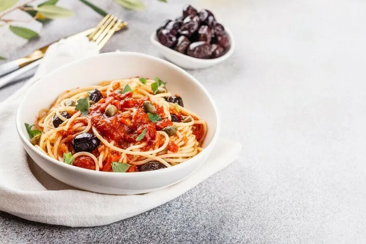 Spaghetti alla puttanesca with anchovies, olives, capers and parmesan cheese