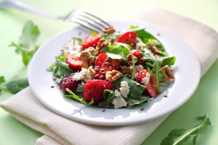 Spinach strawberry salad with olive oil, vinegar and walnuts