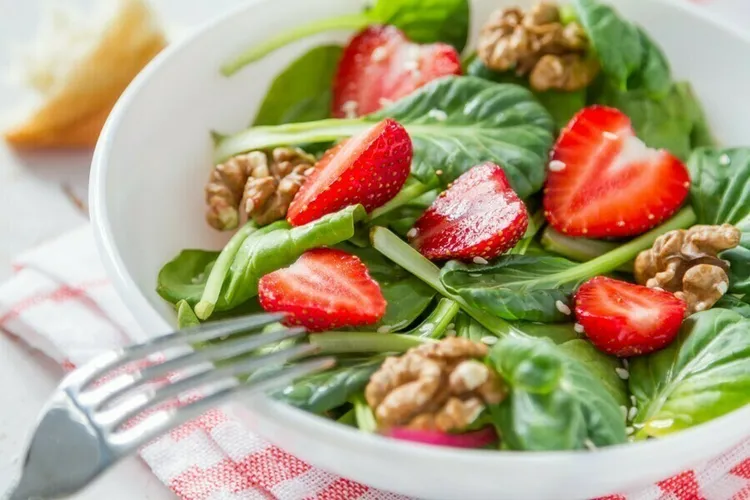 Fresh strawberry and walnut spinach salad with vinegar
