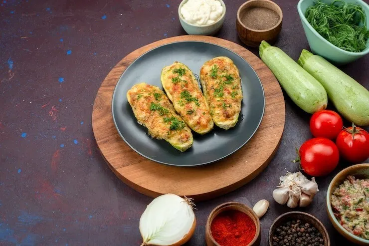 Zucchini boats with cheddar cheese, onion, tomatoes and seasonings