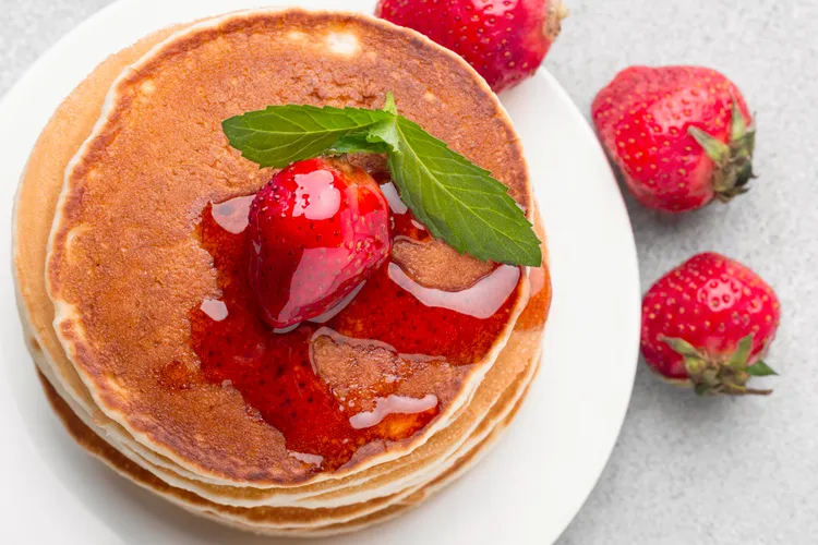 Traditional pancakes with maple syrup butter & strawberries