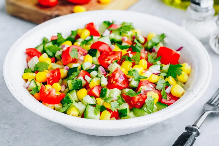Fresh sweet corn and cucumber salad with lettuce and tomatoes